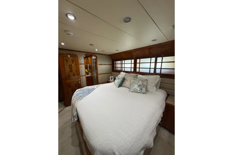 Slide: The Image of Luxurious bedroom interior of a 2001 Hargrave 94 yacht with elegant wood finishes. - 82