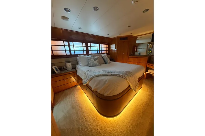 Slide: The Image of Luxurious bedroom interior of 2001 Hargrave 94 yacht with ambient lighting and elegant wood finishes. - 83