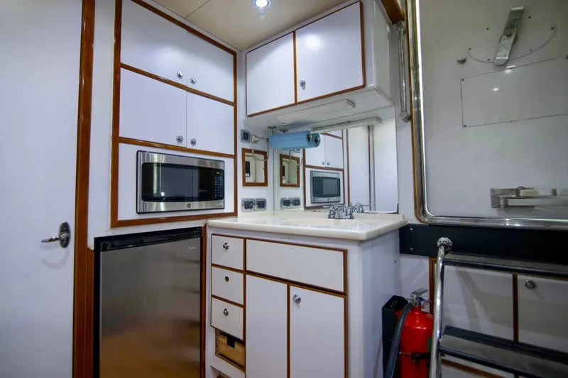 Slide: The Image of Compact kitchen area in a 2001 Hargrave 94 yacht with modern appliances and storage. - 91