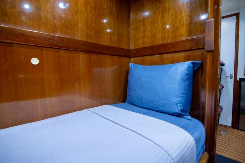 Slide: The Image of Cozy cabin bed with blue bedding in 2001 Hargrave 94 yacht interior. - 92
