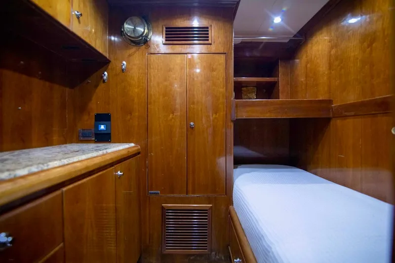 Slide: The Image of Luxurious wooden cabin interior of a 2001 Hargrave 94 yacht with bunk bed and storage. - 94