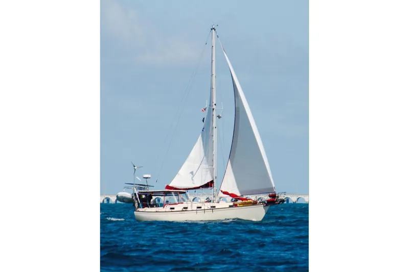 The Image of 1989 Island Packet 35 sailboat navigating blue ocean waters under clear skies. - 0