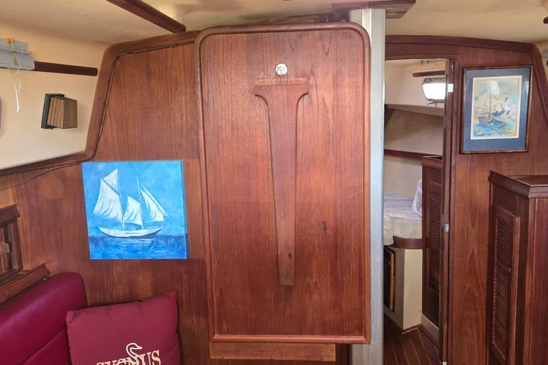 Slide: The Image of Interior of 1989 Island Packet 35 sailboat with wooden paneling and nautical artwork. - 29