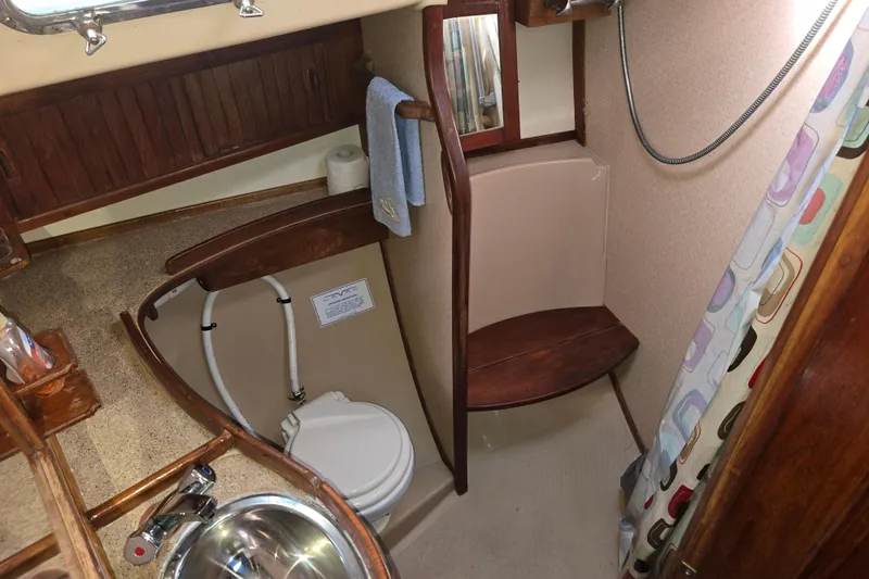 Slide: The Image of 1989 Island Packet 35 yacht bathroom with sink, toilet, and shower area. - 49