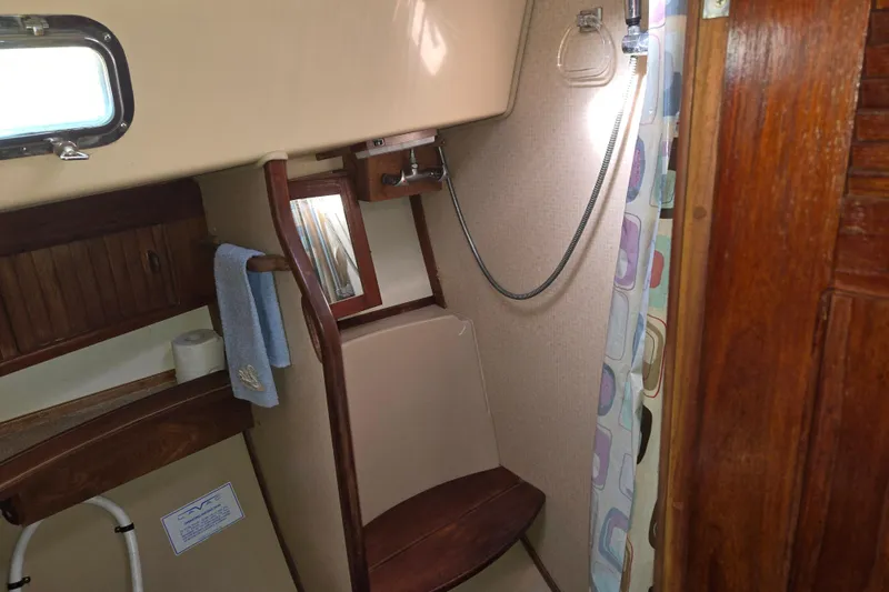 Slide: The Image of Interior of 1989 Island Packet 35 sailboat bathroom with shower and wooden accents. - 50
