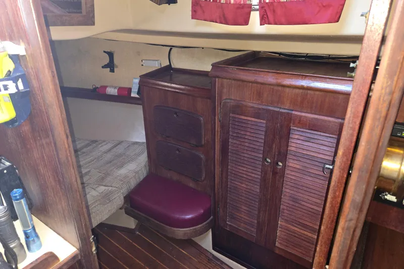Slide: The Image of Interior of 1989 Island Packet 35 sailboat with wooden cabinetry and seating area. - 52