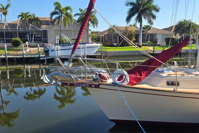 Slide: The Image of 1989 Island Packet 35 sailboat docked near waterfront homes with palm trees. - 54