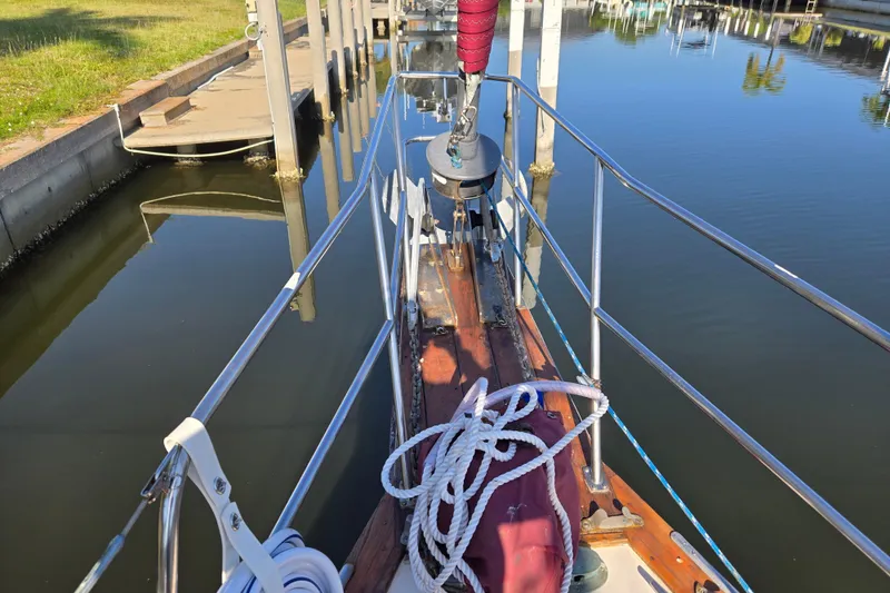 Slide: The Image of Bow view of 1989 Island Packet 35 sailboat docked in calm marina waters. - 58