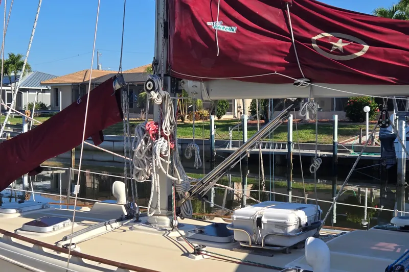 Slide: The Image of 1989 Island Packet 35 sailboat docked, featuring maroon sails and rigging. - 67
