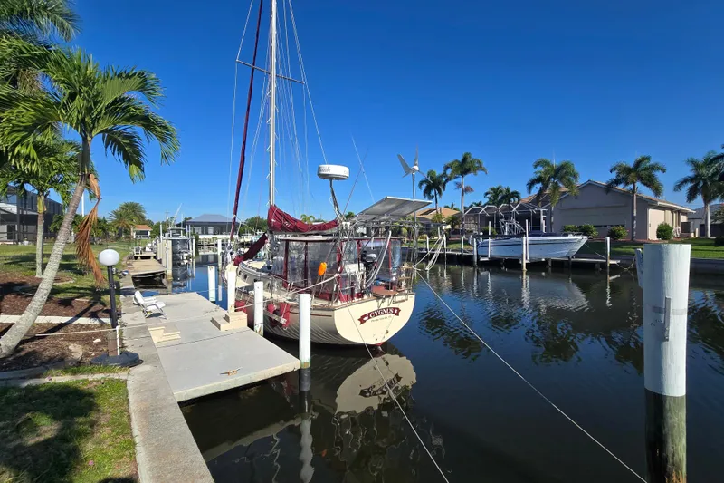 Slide: The Image of 1989 Island Packet 35 sailboat docked in a sunny marina with palm trees. - 71