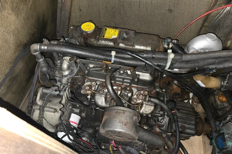Slide: The Image of Engine compartment of a 1989 Island Packet 35 sailboat, showing mechanical components and hoses. - 76