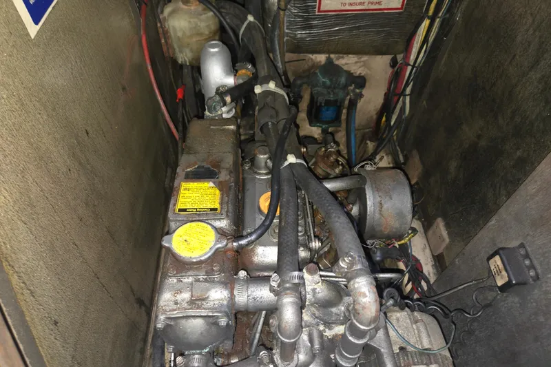Slide: The Image of Engine compartment of a 1989 Island Packet 35 sailboat, showing mechanical components and wiring. - 78