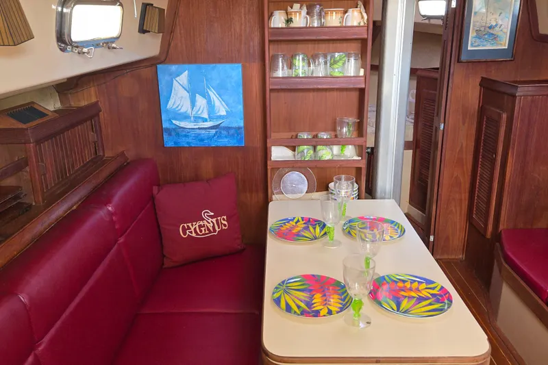 Slide: The Image of Interior of 1989 Island Packet 35 sailboat with dining area, colorful plates, and nautical decor. - 8