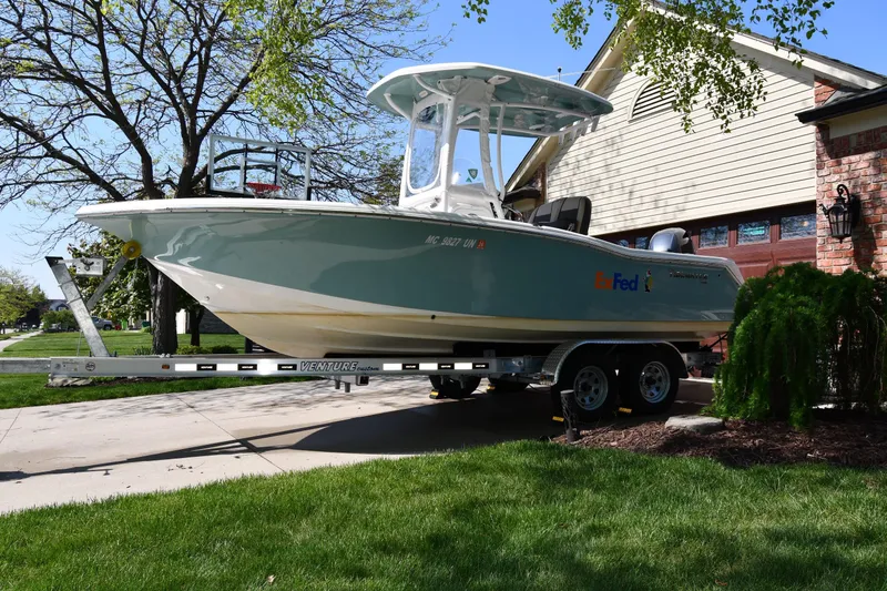 The Image of 2021 Tidewater 210 CC Adventure boat on trailer in residential driveway. - 0
