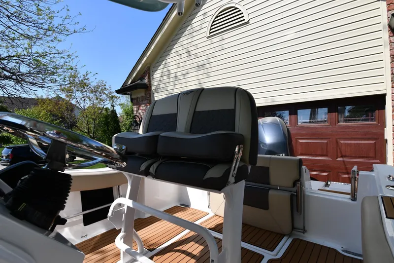 Slide: The Image of 2021 Tidewater 210 CC Adventure boat interior with seating and steering wheel. - 13