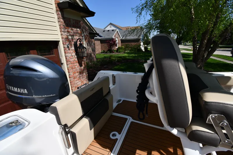 Slide: The Image of 2021 Tidewater 210 CC Adventure boat with Yamaha engine, parked near a brick house. - 17