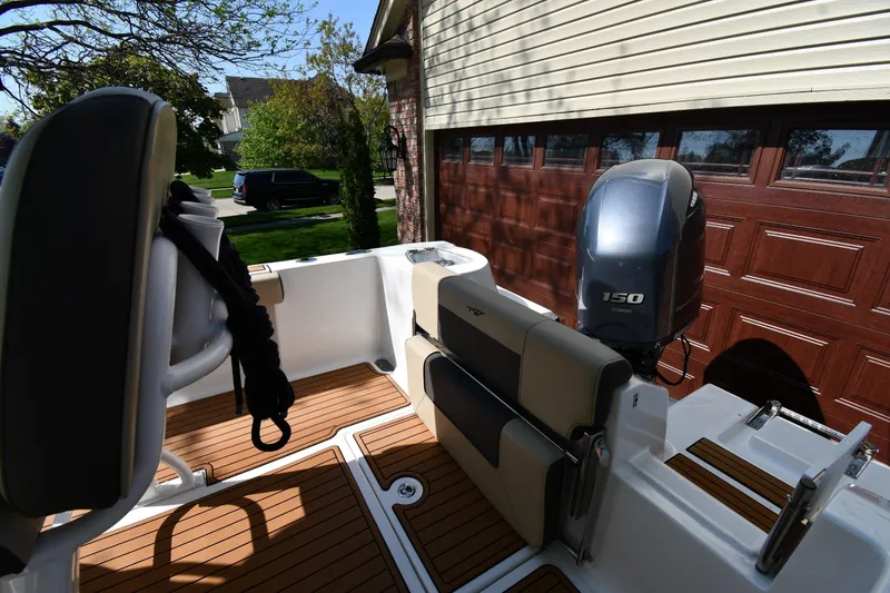 Slide: The Image of 2021 Tidewater 210 CC Adventure boat with Yamaha 150 engine, parked near a garage. - 18