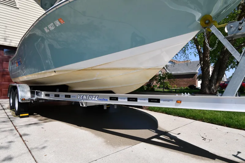 Slide: The Image of 2021 Tidewater 210 CC Adventure boat on Venture trailer in driveway. - 2