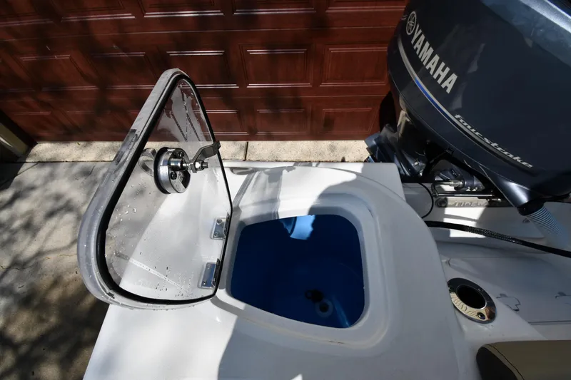 Slide: The Image of 2021 Tidewater 210 CC Adventure boat with Yamaha engine and open storage compartment. - 25