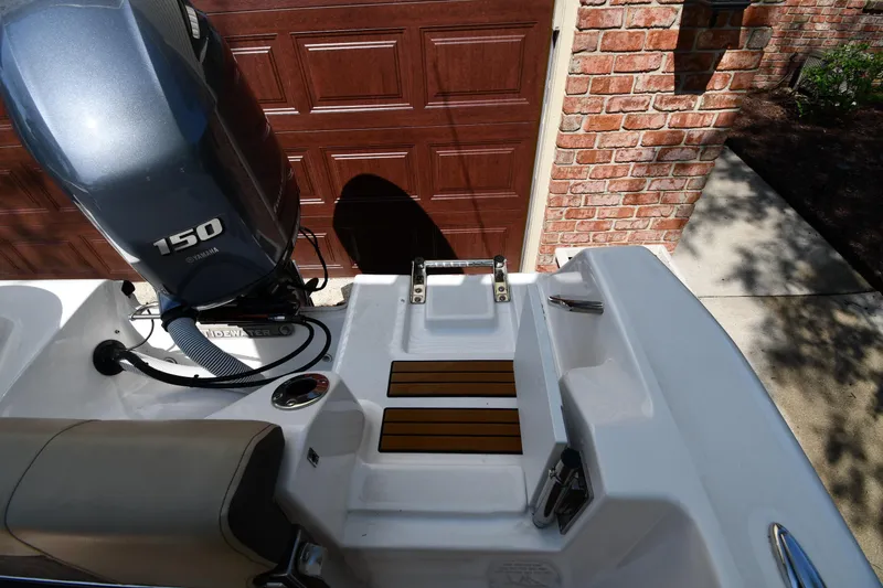 Slide: The Image of 2021 Tidewater 210 CC Adventure boat with Yamaha 150 engine, parked near brick wall. - 26
