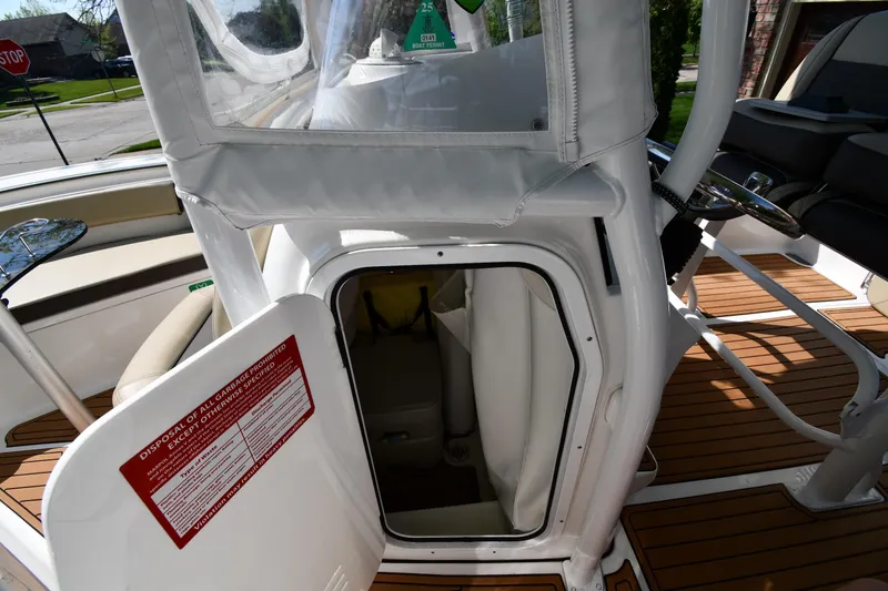 Slide: The Image of 2021 Tidewater 210 CC Adventure boat interior with open storage compartment and teak flooring. - 28