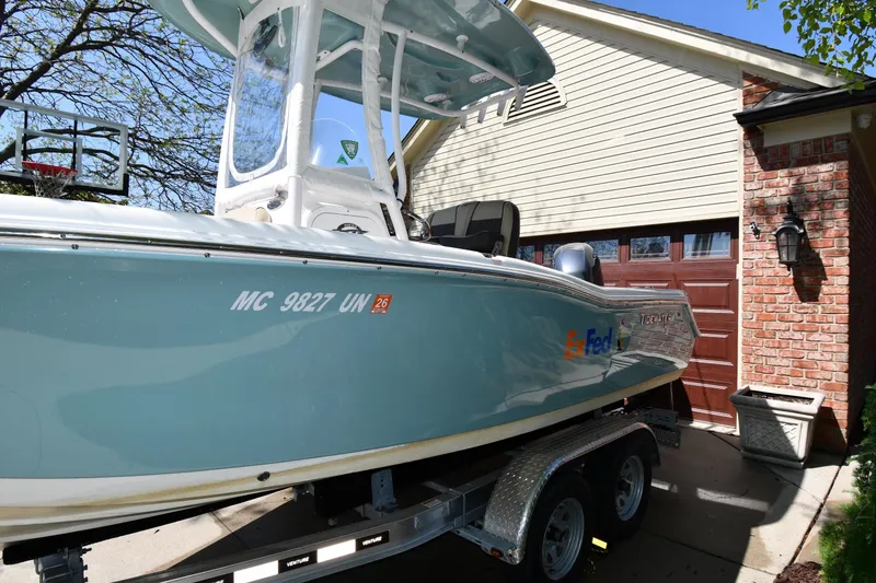 Slide: The Image of 2021 Tidewater 210 CC Adventure boat on trailer, parked near a garage. - 3