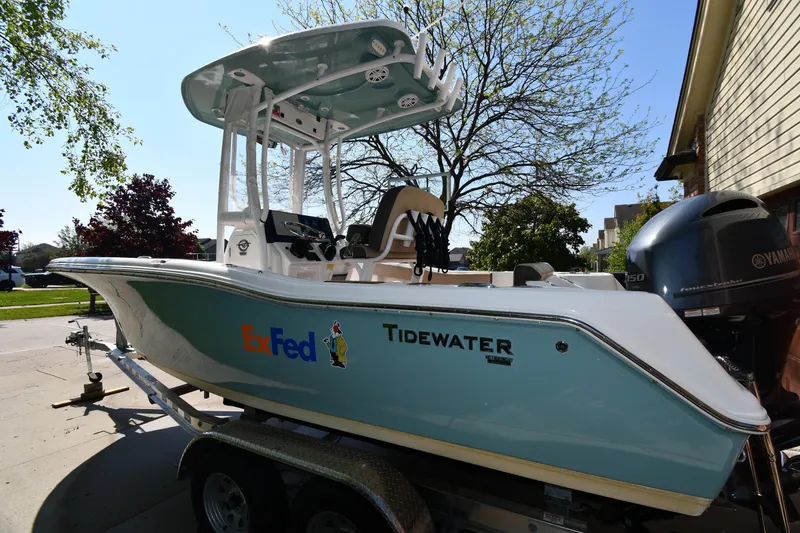 Slide: The Image of 2021 Tidewater 210 CC Adventure boat on trailer, parked outdoors with Yamaha engine. - 4