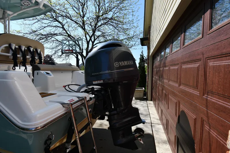 Slide: The Image of 2021 Tidewater 210 CC Adventure boat with Yamaha outboard motor near a garage. - 5