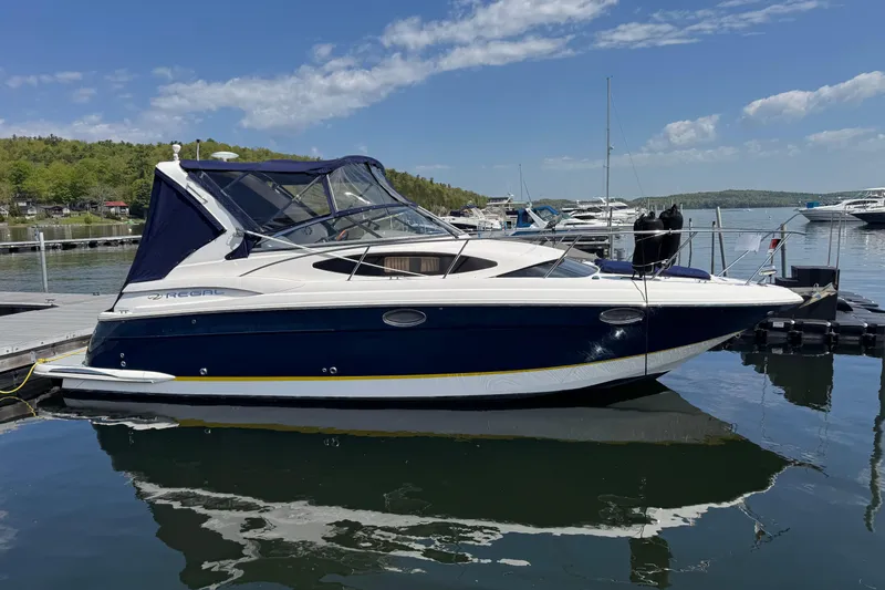 Slide: The Image of 2007 Regal 3060 Window Express boat docked on a serene lake under a clear sky. - 1