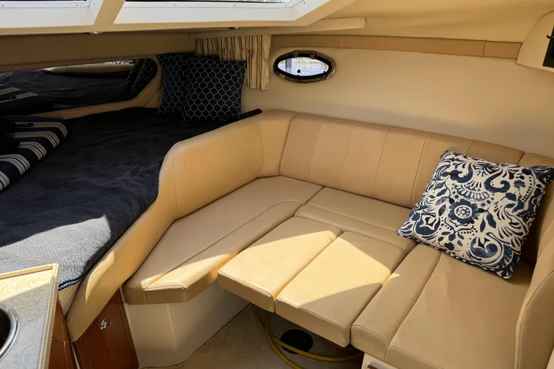 Slide: The Image of Interior of 2007 Regal 3060 Window Express boat with beige seating and decorative pillows. - 17