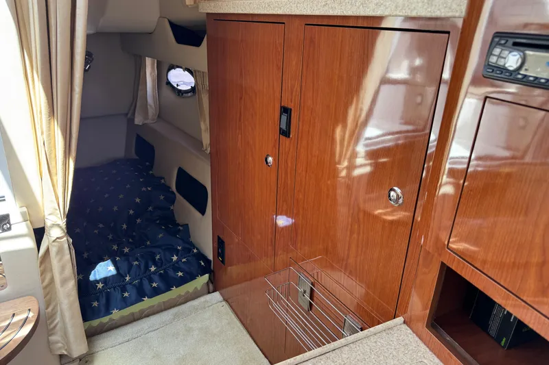 Slide: The Image of 2007 Regal 3060 Window Express cabin interior with wood finish and cozy sleeping area. - 18