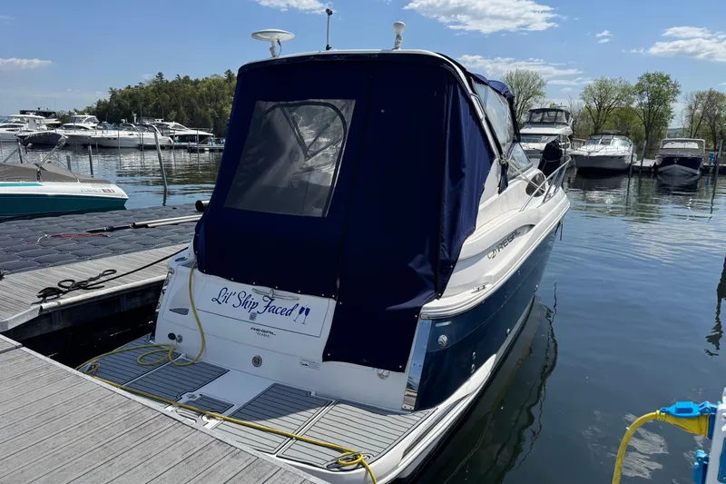 Slide: The Image of 2007 Regal 3060 Window Express boat docked at marina, rear view with cover. - 2