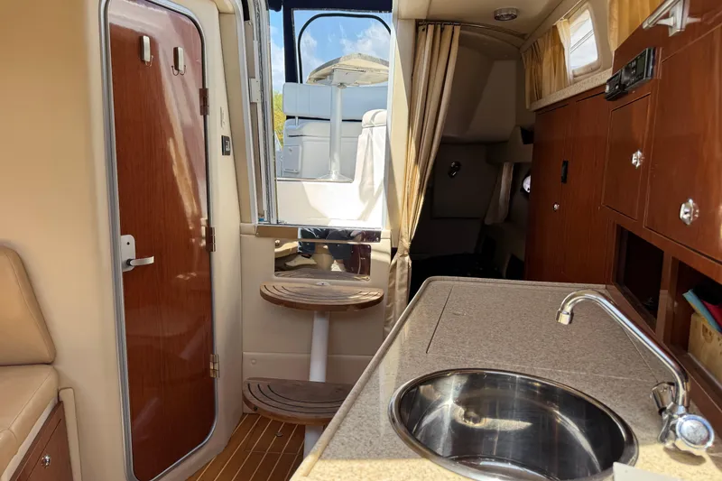 Slide: The Image of Interior of 2007 Regal 3060 Window Express boat with kitchenette and seating area. - 23