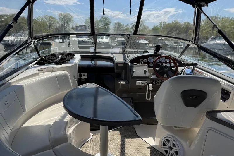 Slide: The Image of 2007 Regal 3060 Window Express boat interior with helm, seating, and table under clear skies. - 5