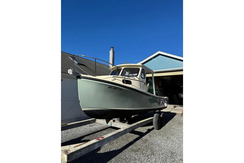 Slide: The Image of 2020 Eastern 22 Sisu Hardtop boat on trailer, parked near a garage. - 1