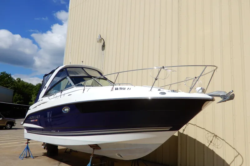 The Image of 2022 Monterey 295 Sport Yacht displayed outdoors against a beige wall. - 0