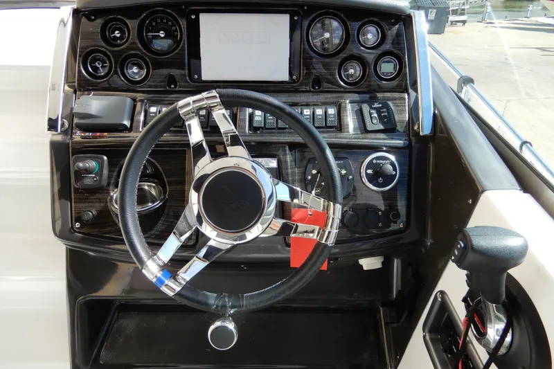 Slide: The Image of 2022 Monterey 295 Sport Yacht dashboard with modern controls and sleek steering wheel. - 23