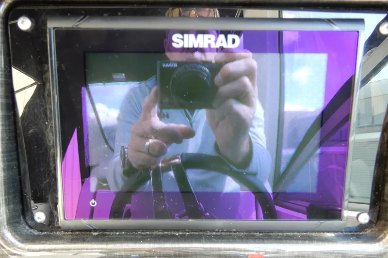Slide: The Image of Simrad display on 2022 Monterey 295 Sport Yacht, reflecting a person taking a photo. - 24
