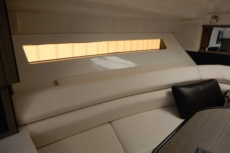 Slide: The Image of Interior of 2022 Monterey 295 Sport Yacht with beige seating and window view. - 36