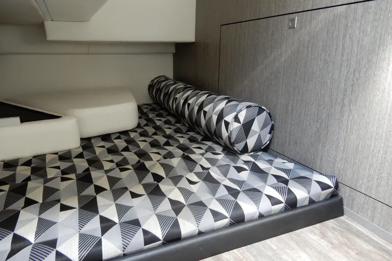 Slide: The Image of Interior cabin of 2022 Monterey 295 Sport Yacht with geometric-patterned bedding. - 38