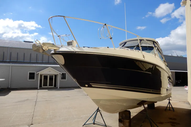 Slide: The Image of 2022 Monterey 295 Sport Yacht on stands, displayed outdoors under a clear blue sky. - 4