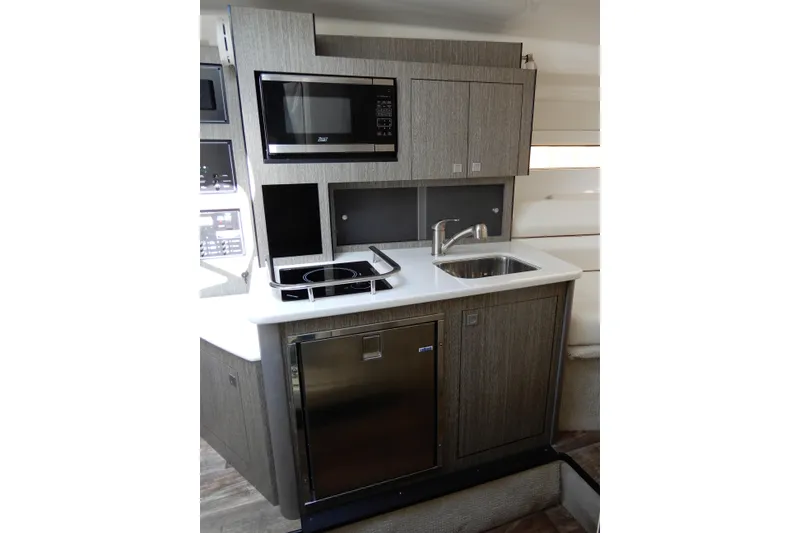 Slide: The Image of Modern kitchenette in 2022 Monterey 295 Sport Yacht with microwave, sink, and stove. - 41