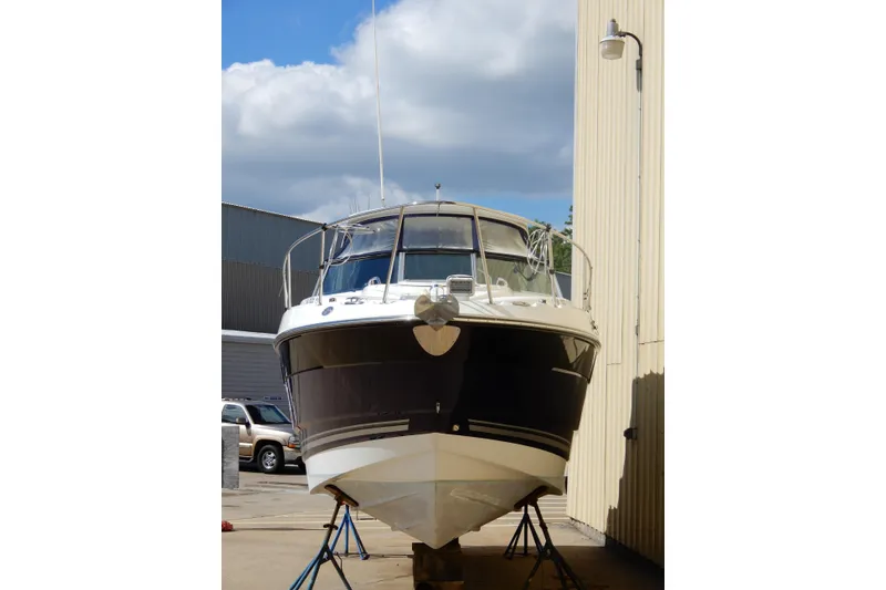 Slide: The Image of 2022 Monterey 295 Sport Yacht on stands, dockside view with blue sky background. - 5
