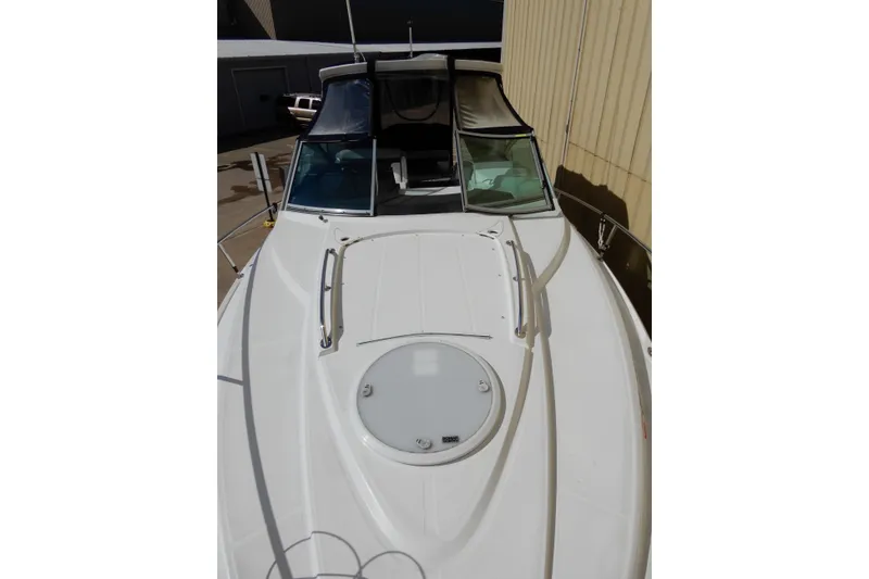 Slide: The Image of 2022 Monterey 295 Sport Yacht, sleek white exterior, docked in a marina setting. - 6