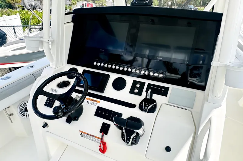 Slide: The Image of 2020 Regulator 34 boat dashboard with steering wheel and electronic controls. - 10