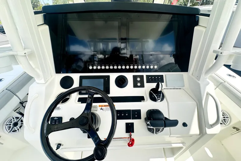 Slide: The Image of 2020 Regulator 34 boat dashboard with steering wheel, controls, and navigation screens. - 11