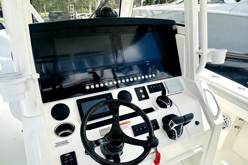 Slide: The Image of 2020 Regulator 34 boat dashboard with dual screens and steering wheel. - 12