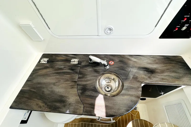 Slide: The Image of 2020 Regulator 34 boat interior with sleek countertop and stainless steel sink. - 24
