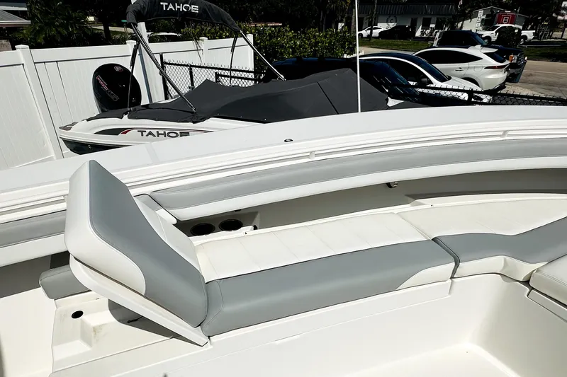Slide: The Image of 2020 Regulator 34 boat with sleek seating, parked near a Tahoe boat. - 8