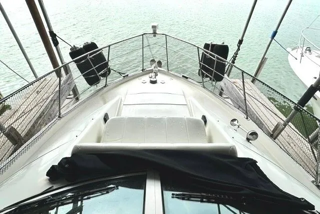 Slide: The Image of 2004 Carver 360 Mariner yacht bow view with railing and water backdrop. - 20
